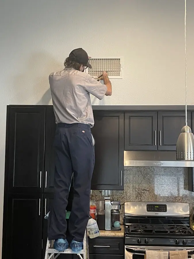 Technician inspecting an air vent during HVAC service in Southampton